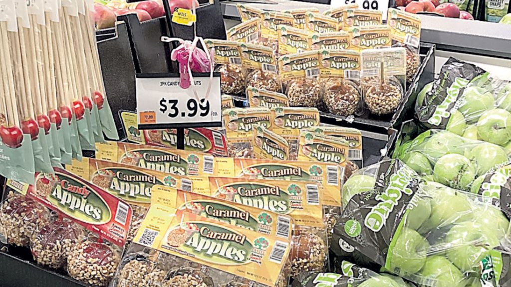 Complementary fall products, like caramel or chocolate-covered apples, add breaks to typical produce displays and encourage impulse buys.