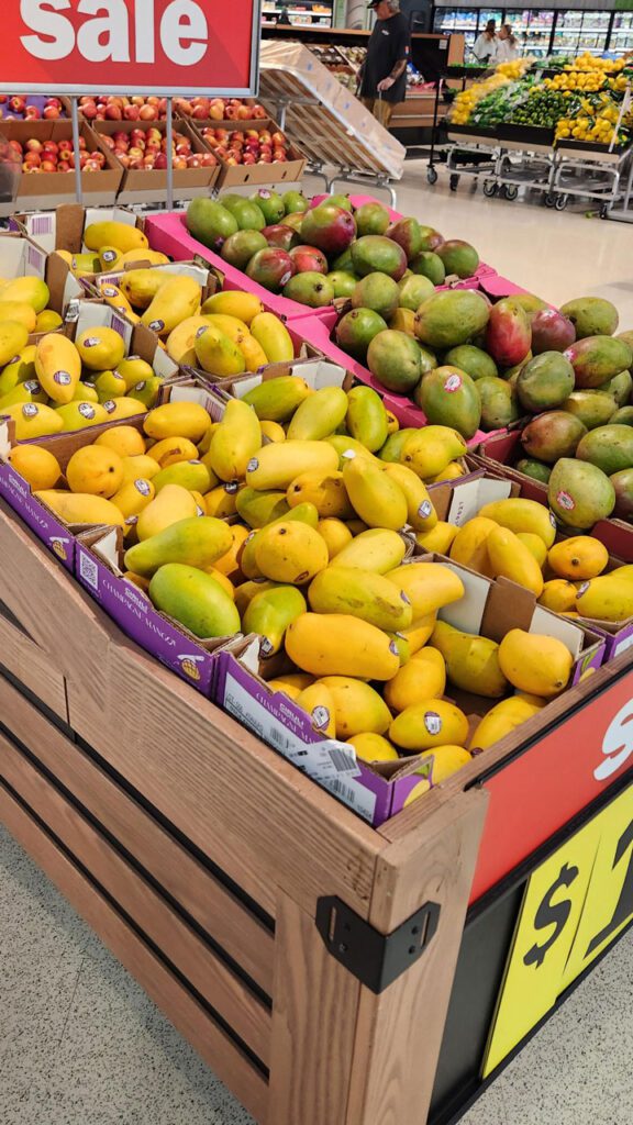 Large displays of mangos stacked high are best to draw attention and allow consumers to have many to select from.