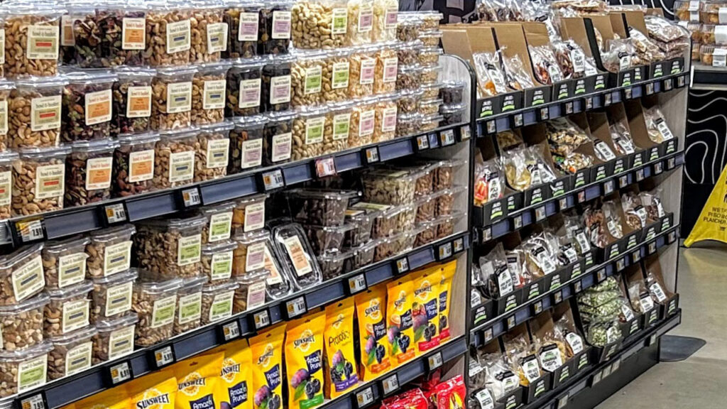 As shoppers enter The Fresh Grocer of Brooklyn’s produce department, they encounter tub nuts, dried fruit and other potential grab-and-go edibles.