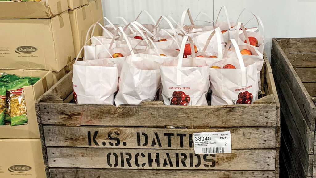 A rustic, farm bin display connects shoppers to the orchard and the traditional harvest season, and helps move apples.